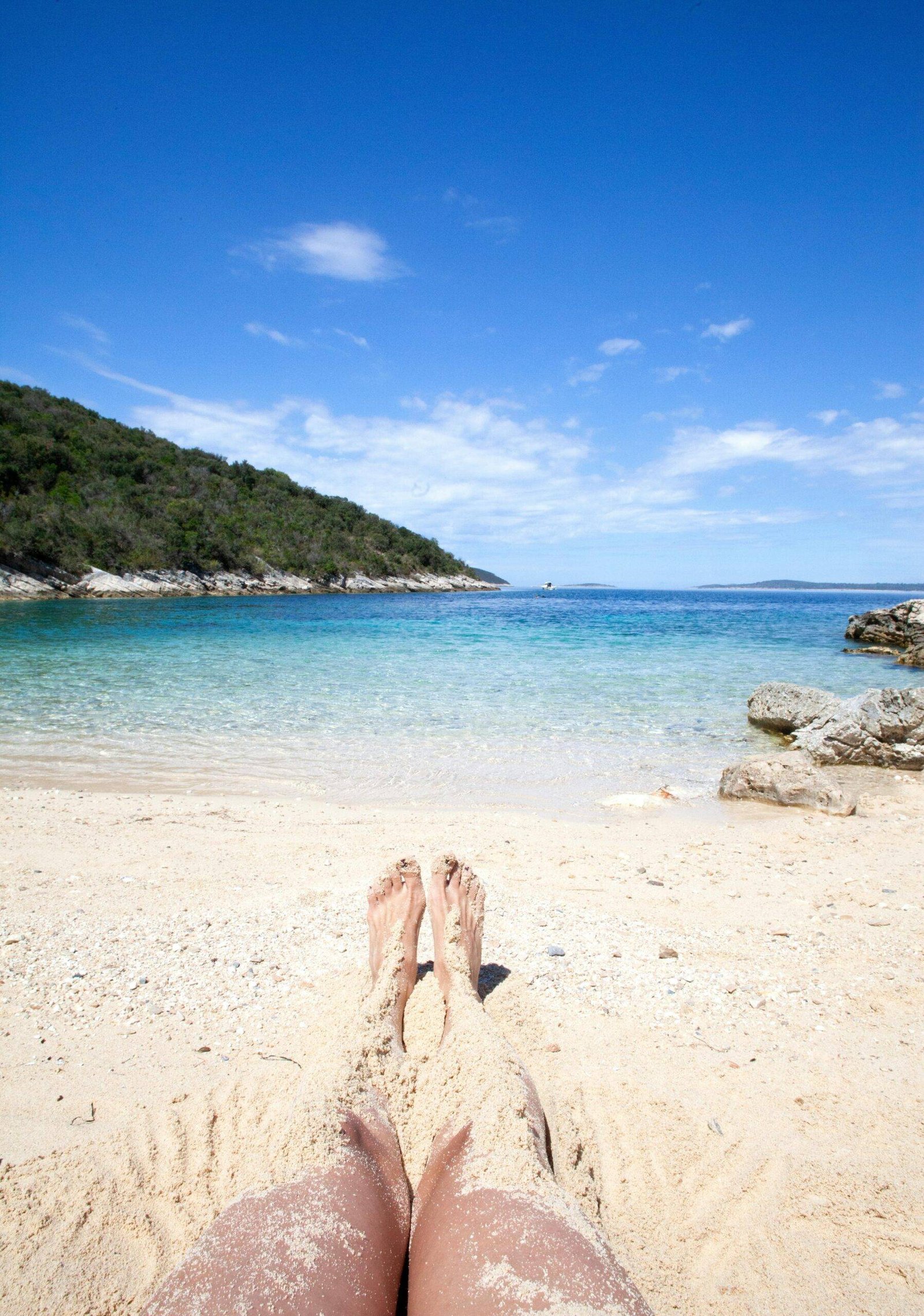 Enjoying a sunny day on a sandy beach in Šolta, Croatia with clear blue skies and turquoise waters.
